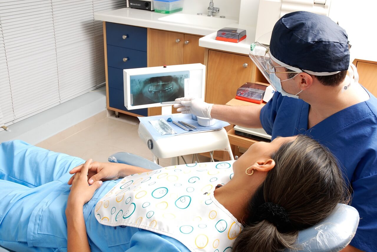 Dentist examining a dental X-ray for accurate diagnosis and treatment planning.