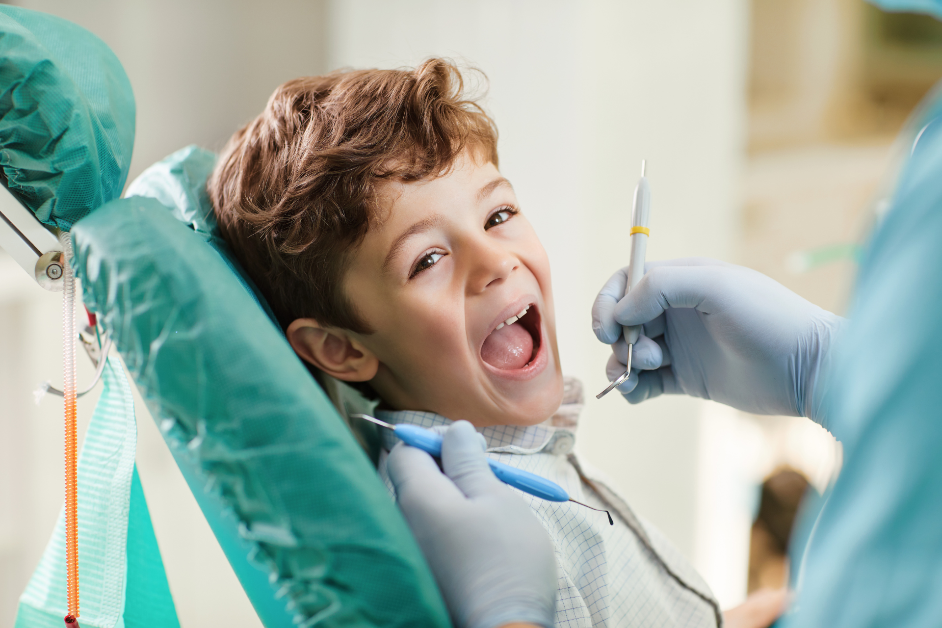 A happy child sitting in a dental chair at Luf Dental, smiling during a comfortable and stress-free dental checkup with a caring dentist.